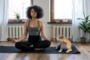 a woman meditating with her dog