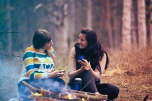 two women talking at bonfire