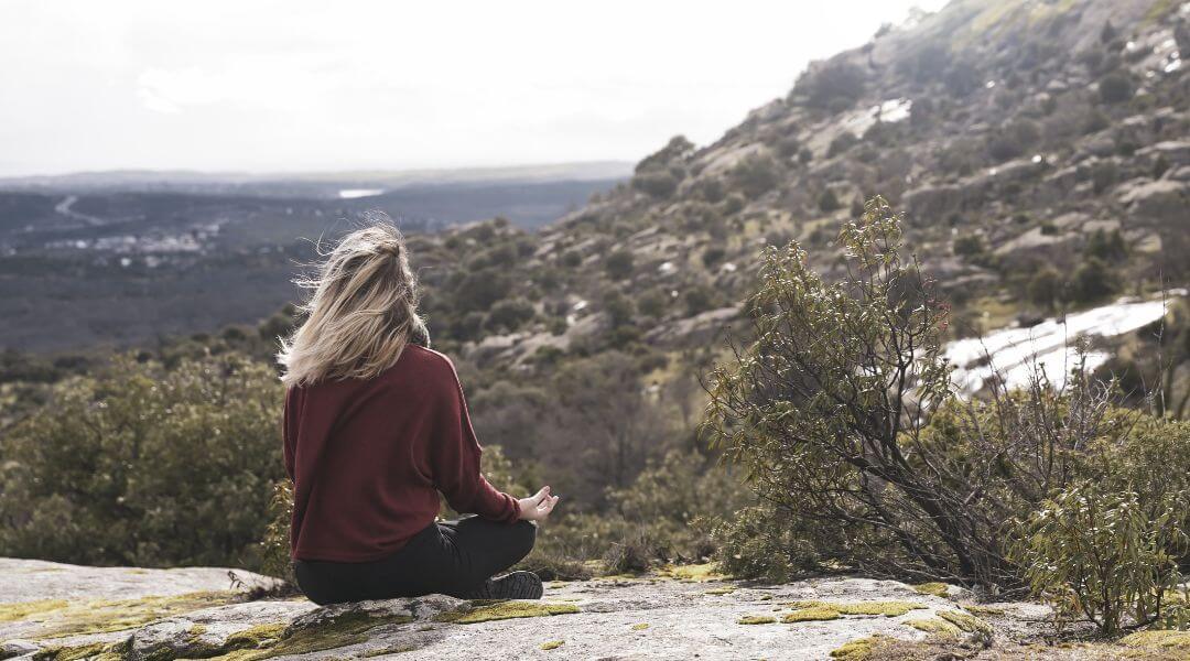 lady meditating in the mountains